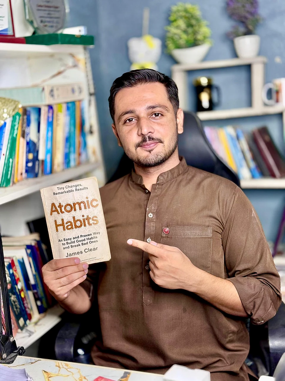 Gohar Rehman Rajput holding the book Atomic Habits